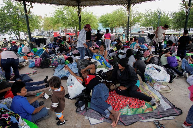 Central American asylum seekers rest in a public park after