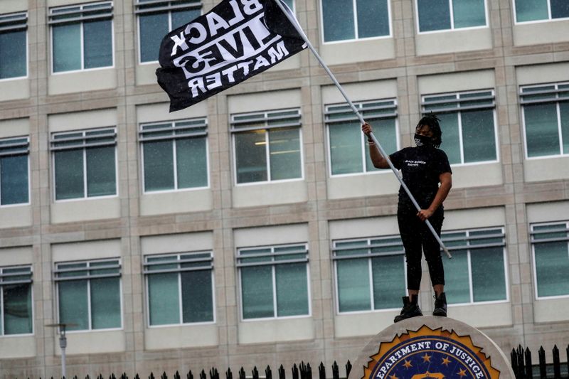 FILE PHOTO: A protester carries a Black Lives Matter flag