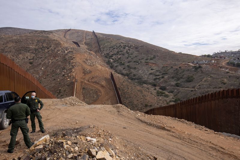 U.S. border patrol agents stand near the location of halted