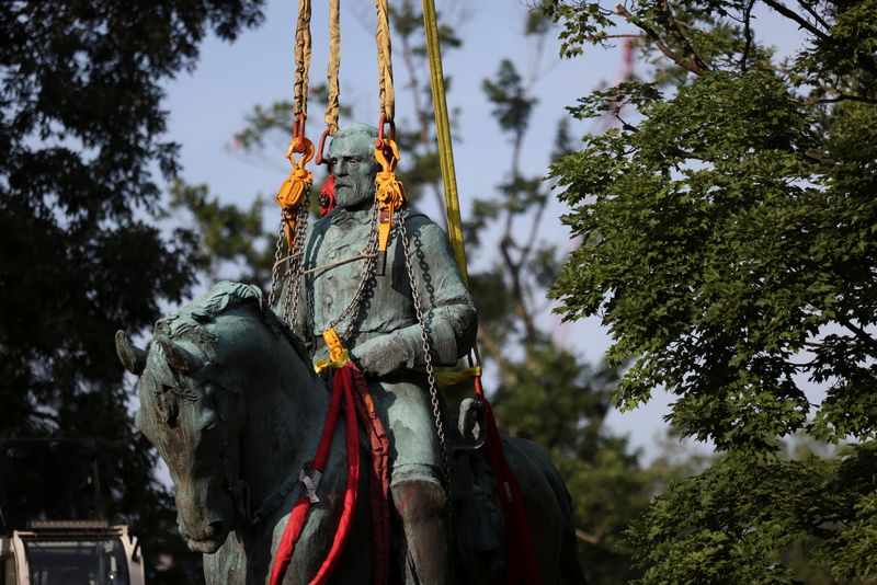 Workers remove a statue of Confederate General Robert E. Lee,