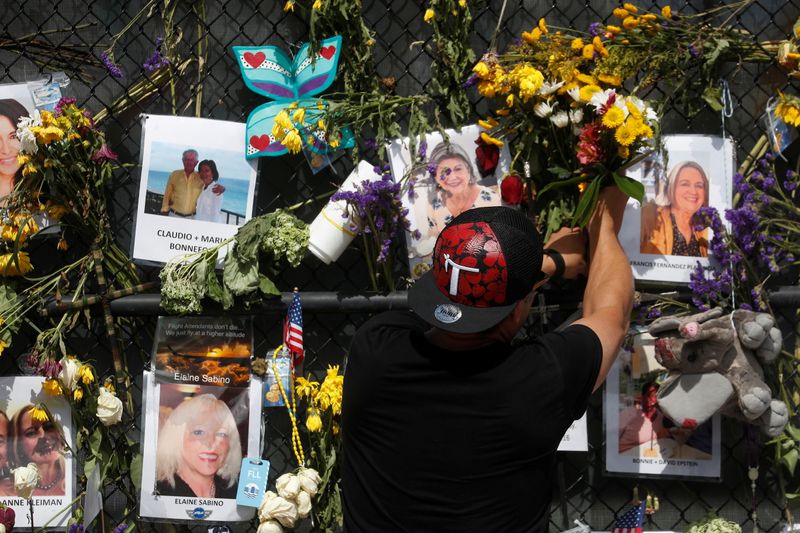 A man places flowers on a makeshift memorial for the