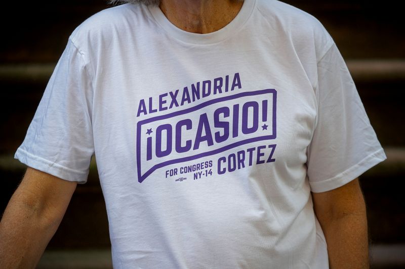 Peter Hogness poses wearing his Alexandria Ocasio-Cortez branded T-shirt in