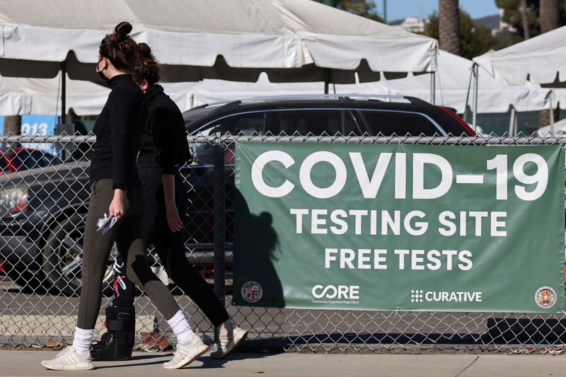 Women walk past a coronavirus testing site in Los Angeles