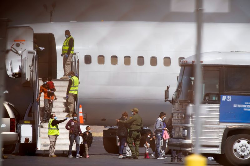 FILE PHOTO: Migrants leave a chartered airplane in El Paso