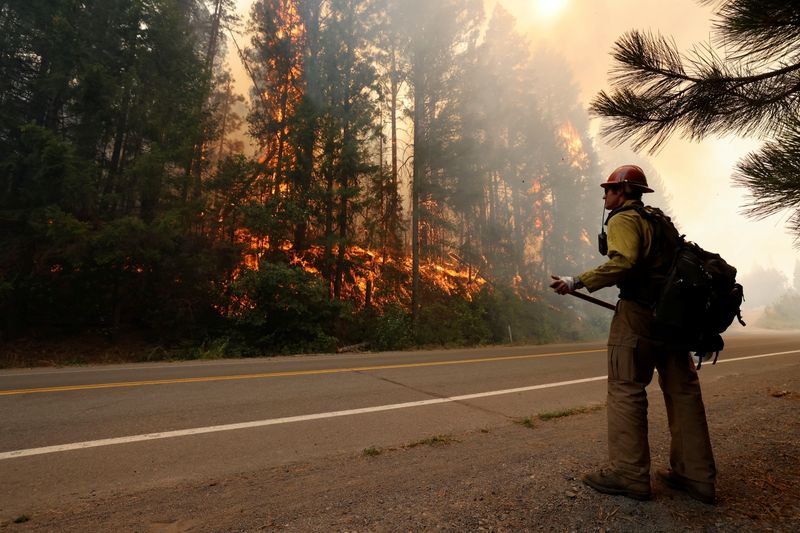 Firefighter David Molter monitors flames at the Dixie Fire near