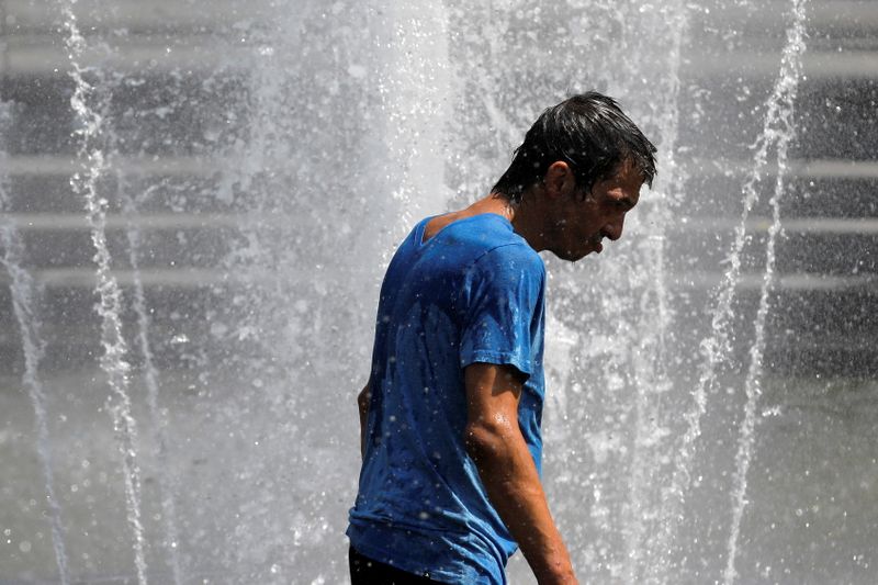 A man walks in the fountain in Washington Square Park