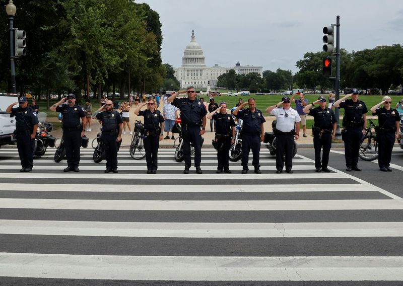 FILE PHOTO: Law enforcement officers salute as a ceremonial procession