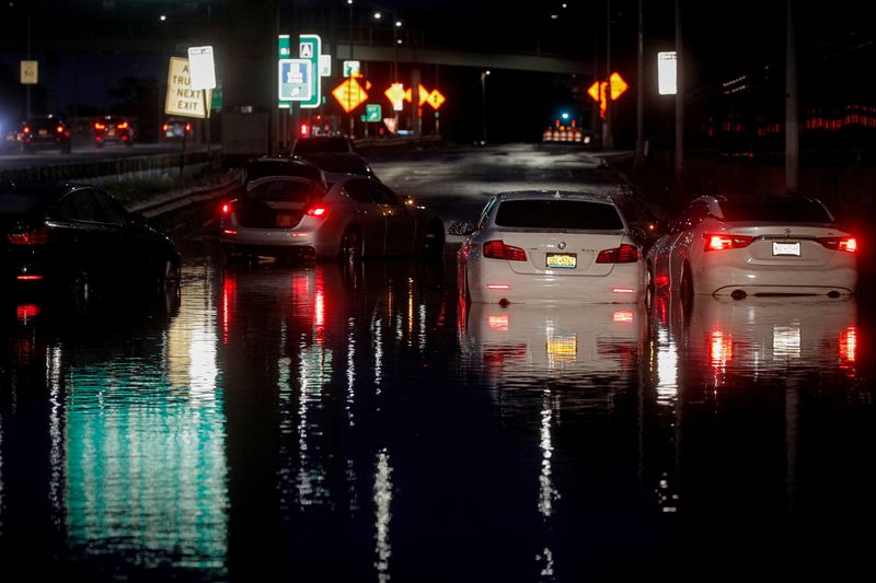 Abandoned cars are left on a flooded highway in Queens,