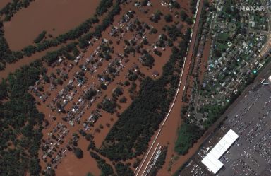 A satellite image shows a rail yard and homes along