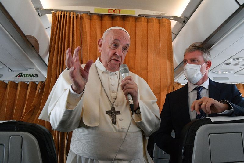Pope Francis speaks to the media on board an Alitalia