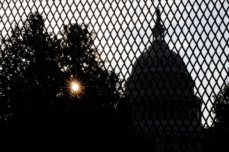 The sun rises behind the U.S. Capitol, surrounded by a