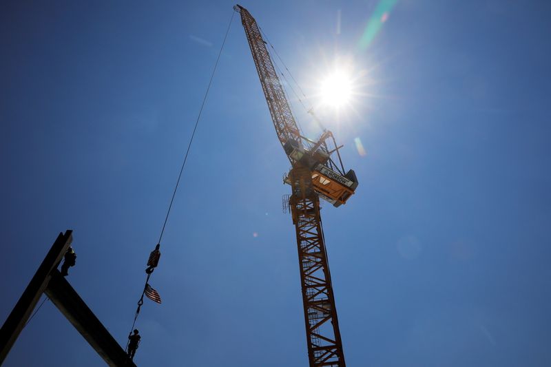 FILE PHOTO: Construction workers install steel beams on high-rise building