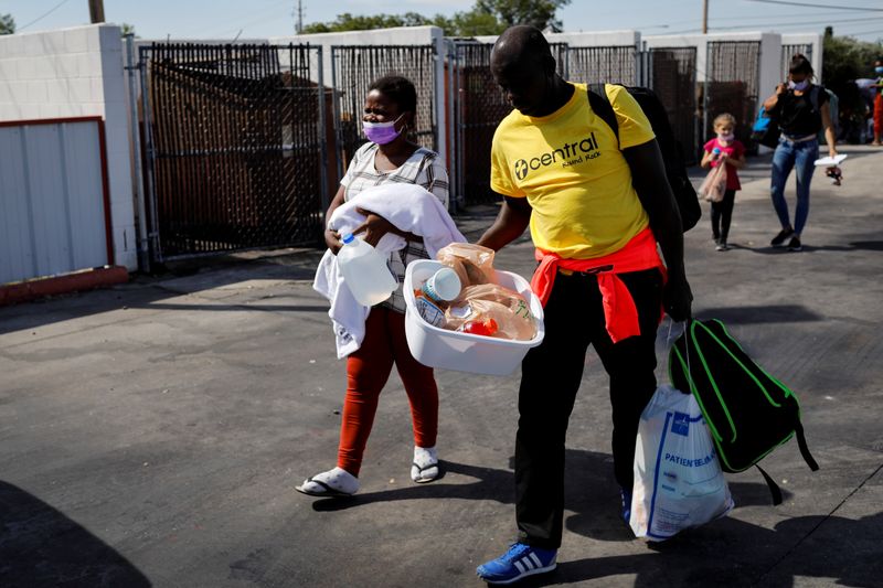 Migrants seeking asylum in the U.S. walk towards a bus