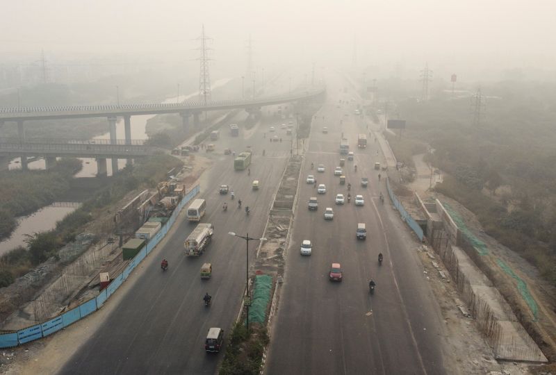 Traffic moves on a highway shrouded in smog in New