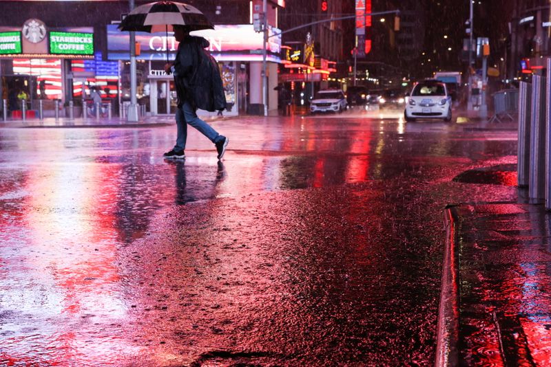 Person walks through Times Square during a nor’easter in New