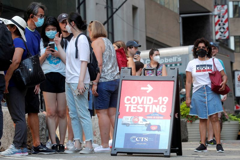 FILE PHOTO: People line up at a coronavirus disease (COVID-19)
