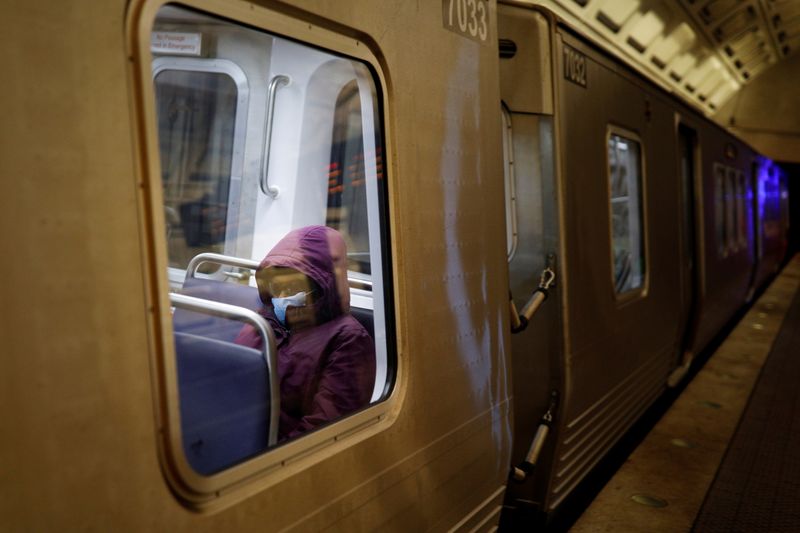 FILE PHOTO: A passenger wears a protective face mask aboard