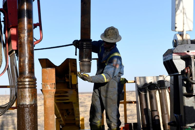 FILE PHOTO: An oil worker removes a thread cap from