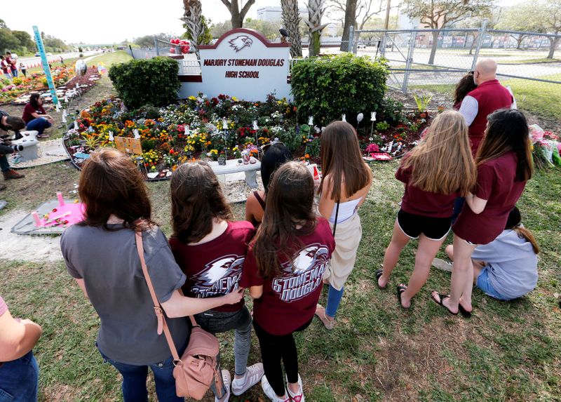 A memorial is viewed by parents and students on campus
