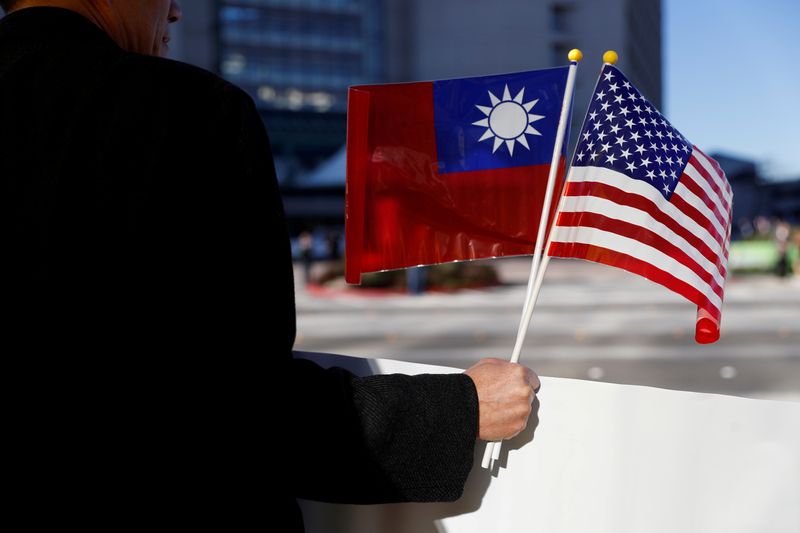 FILE PHOTO: A demonstrator holds flags of Taiwan and the