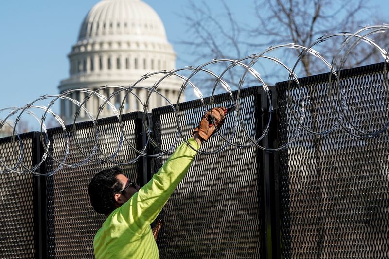 FILE PHOTO: Workers remove razor wire from security fencing near