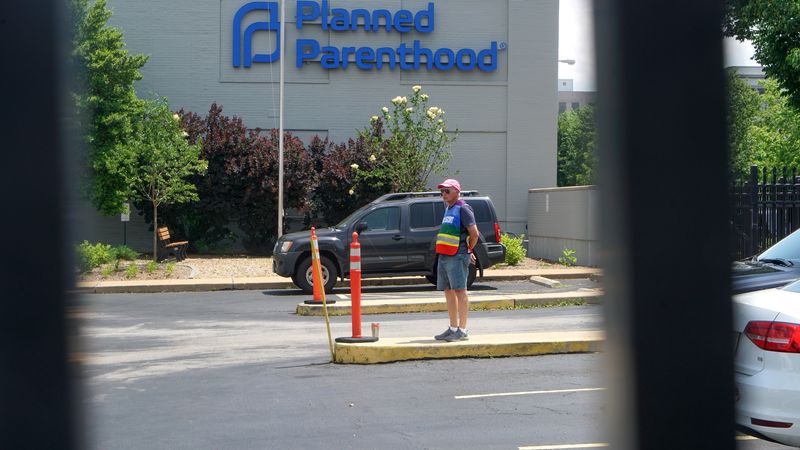 FILE PHOTO: A clinic escort stands outside the Reproductive Health