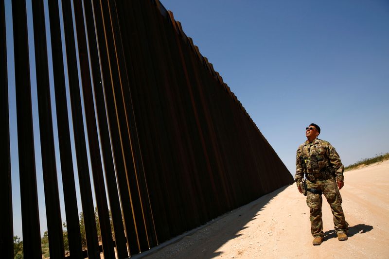 A member of BORSTAR observes the border wall in New