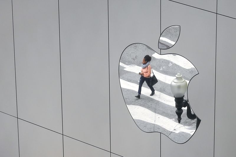 FILE PHOTO:  A woman is reflected in a Apple
