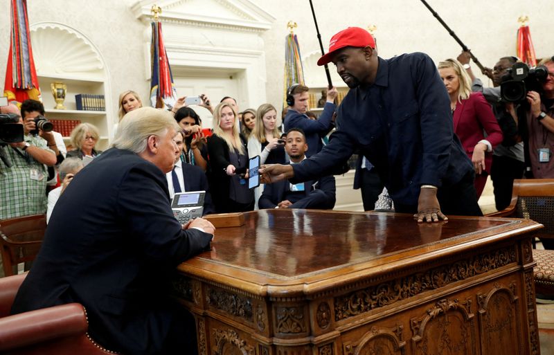 FILE PHOTO: Rapper Kanye West shows President Trump his mobile