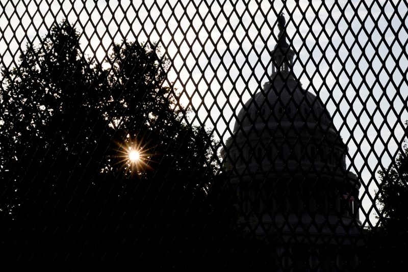 FILE PHOTO: The sun rises behind the U.S. Capitol, surrounded