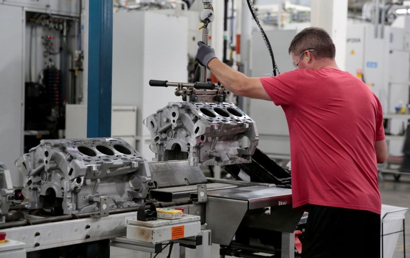 FILE PHOTO: A General Motors assembly worker loads engine block
