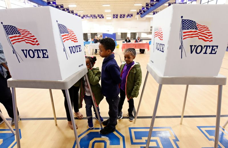 FILE PHOTO: Children watch their mother vote during the U.S.