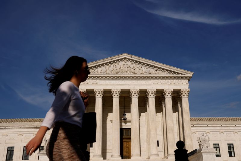 FILE PHOTO: A woman walks past the U.S. Supreme Court
