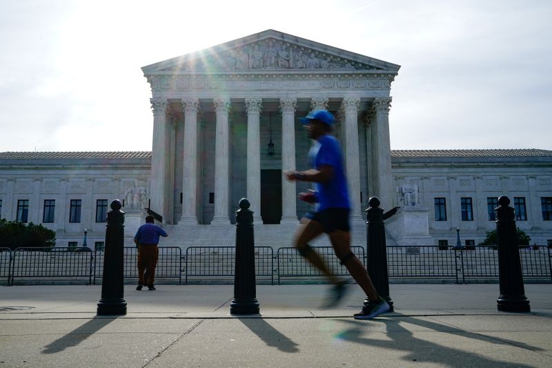 FILE PHOTO: People walk past the U.S. Supreme Court the
