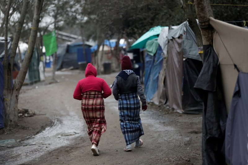 FILE PHOTO: Migrant women using blankets as skirts walk inside