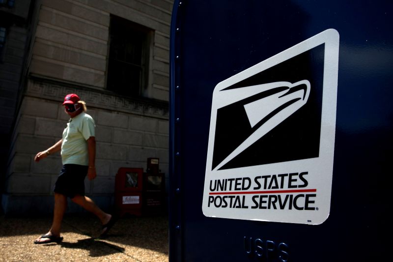 A man walks by a United States Postal Service (USPS)
