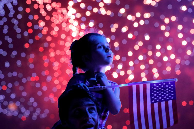 A child holds a U.S. flag as she watches the
