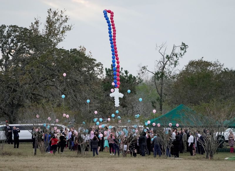FILE PHOTO: Balloons are released during a funeral for victims