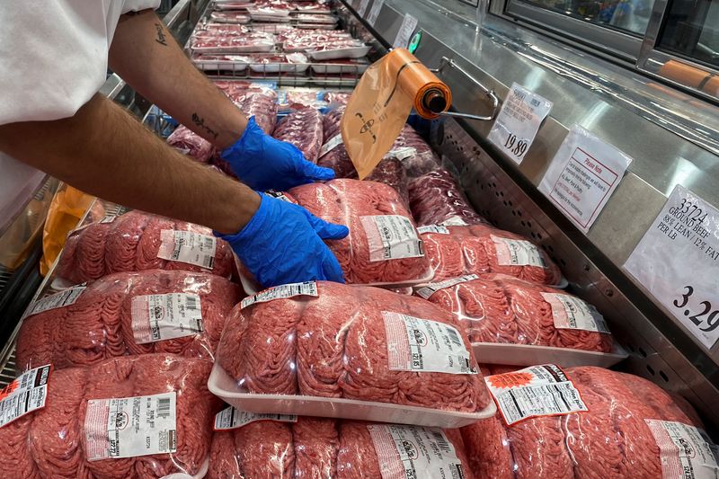 Worker stacks beef in meat section of Costco during coronavirus