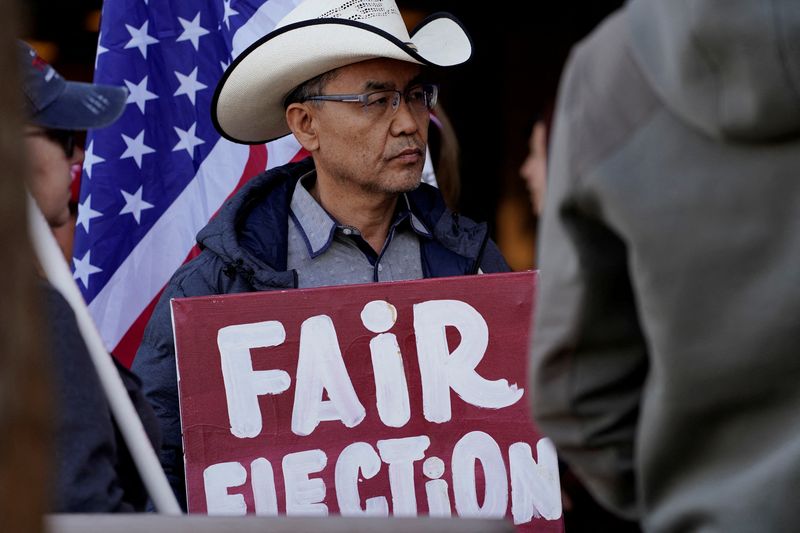 FILE PHOTO: A protestor holds a placard as Arizona electors