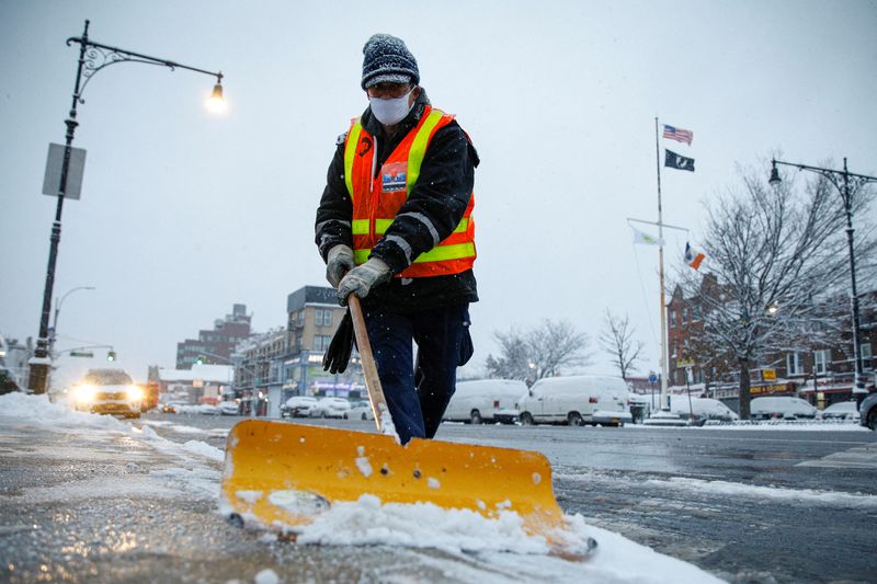 A New York City Transit worker clears snow from a
