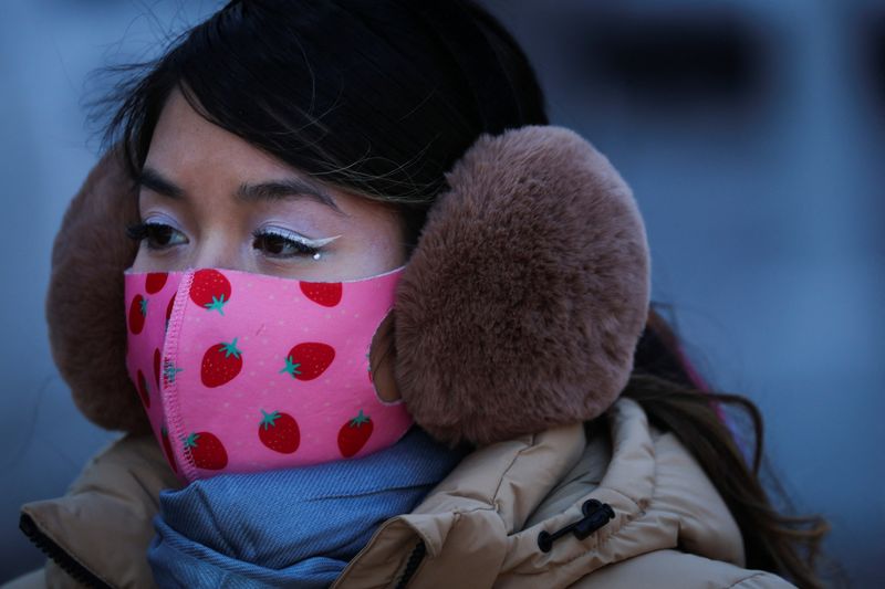 Woman wears a protective face mask and thick ear muffs