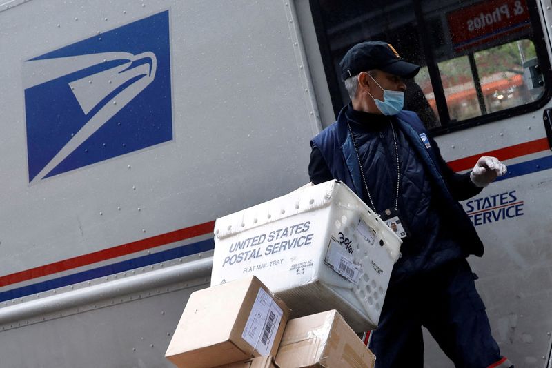 FILE PHOTO: United States Postal Service (USPS) worker unloads packages