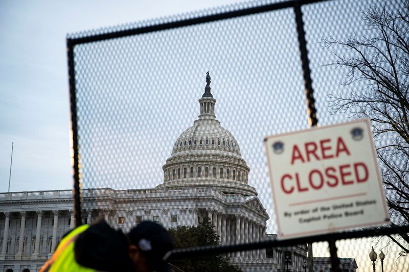 Workers install security fencing around the perimeter of the U.S.