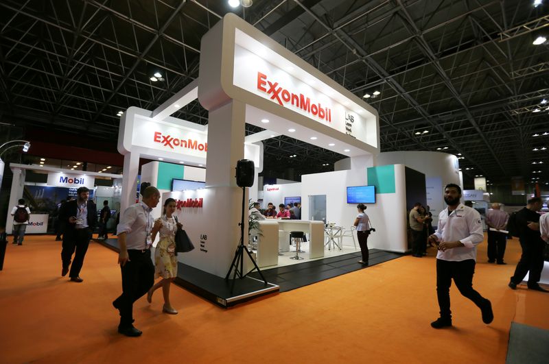 People walk near the booth of the Exxon Mobil Corp