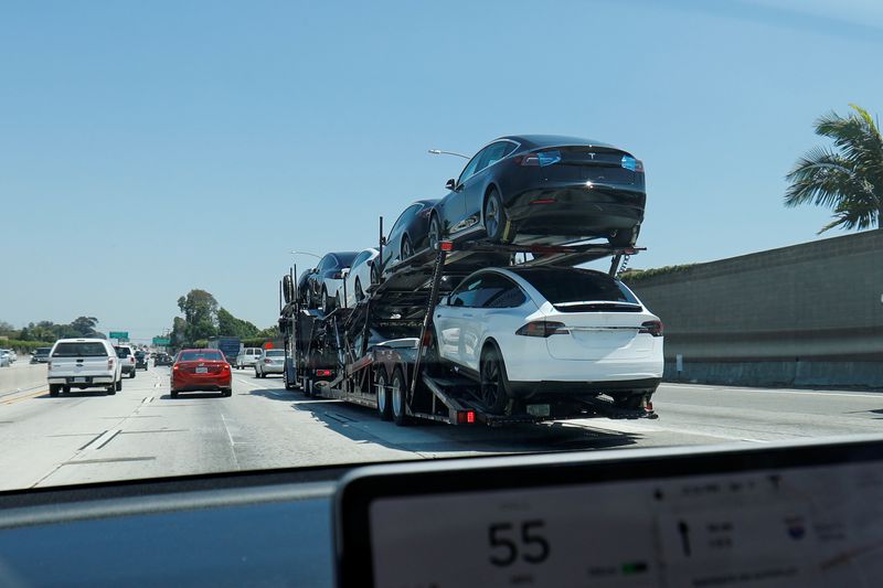 Newly built Tesla electric vehicles are transported for delivery along