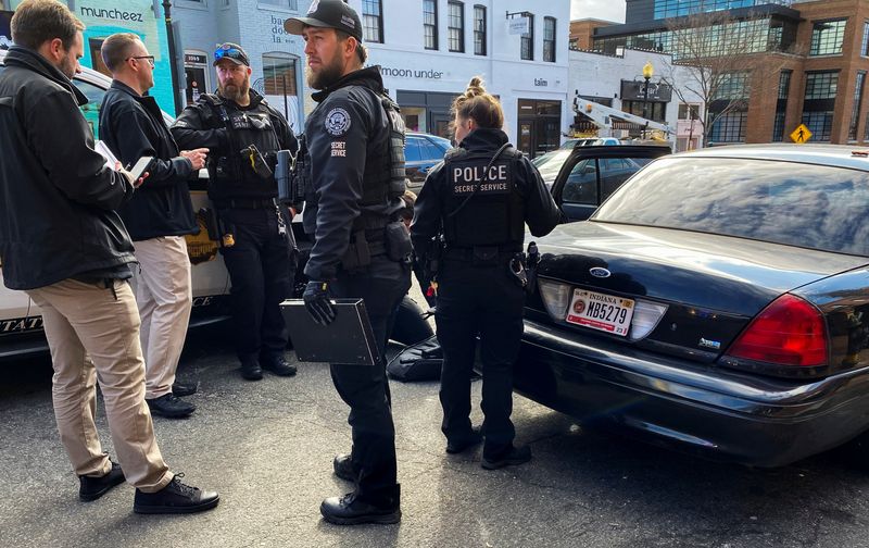 U.S. Secret Service officers search a car and detain men