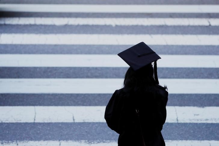 FILE PHOTO: A graduating student waits to cross the street