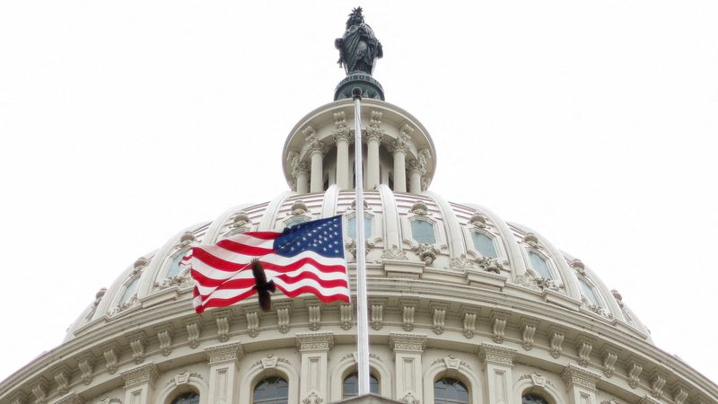 FILE PHOTO: The U.S. flag flies over the U.S. Capitol