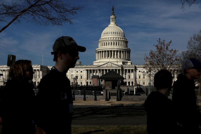 FILE PHOTO: Pedestrians walk by the United States Capitol building